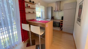 A modern kitchen with a dining area, wooden cabinets, and a built-in oven.