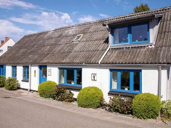 A white building with blue-framed windows and a corrugated metal roof. - 6 Person Holiday Home in Samso (Samsø)