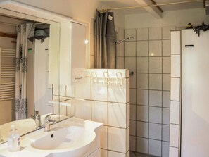 A bathroom with a sink, mirror, shower, and towel rack. - 6 Person Holiday Home in Samso (Samsø)