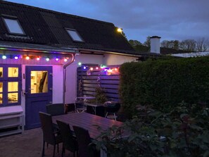 A house with a blue door, a wooden table, and chairs outside. - 6 Person Holiday Home in Samso (Samsø)