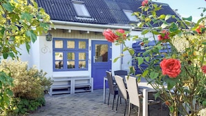 A house with a blue door, a window with multiple panes, and a small porch area. - 6 Person Holiday Home in Samso (Samsø)