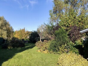 A well-maintained garden with a wooden structure, a lawn, and various shrubs. - 6 Person Holiday Home in Samso (Samsø)
