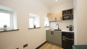 A compact kitchen with a microwave, coffee maker, and a small refrigerator. - The Sixty 19 Stylish Studios and Apt. (Cardiff)