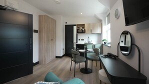 A modern apartment with a dining area, kitchen, and a large mirror. - The Sixty 19 Stylish Studios and Apt. (Cardiff)