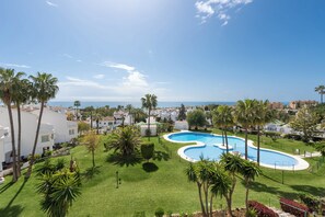A resort with a pool, palm trees, and a view of the sea. - Jardines de Calahonda IX | Sea View & Pool (Mijas Costa)