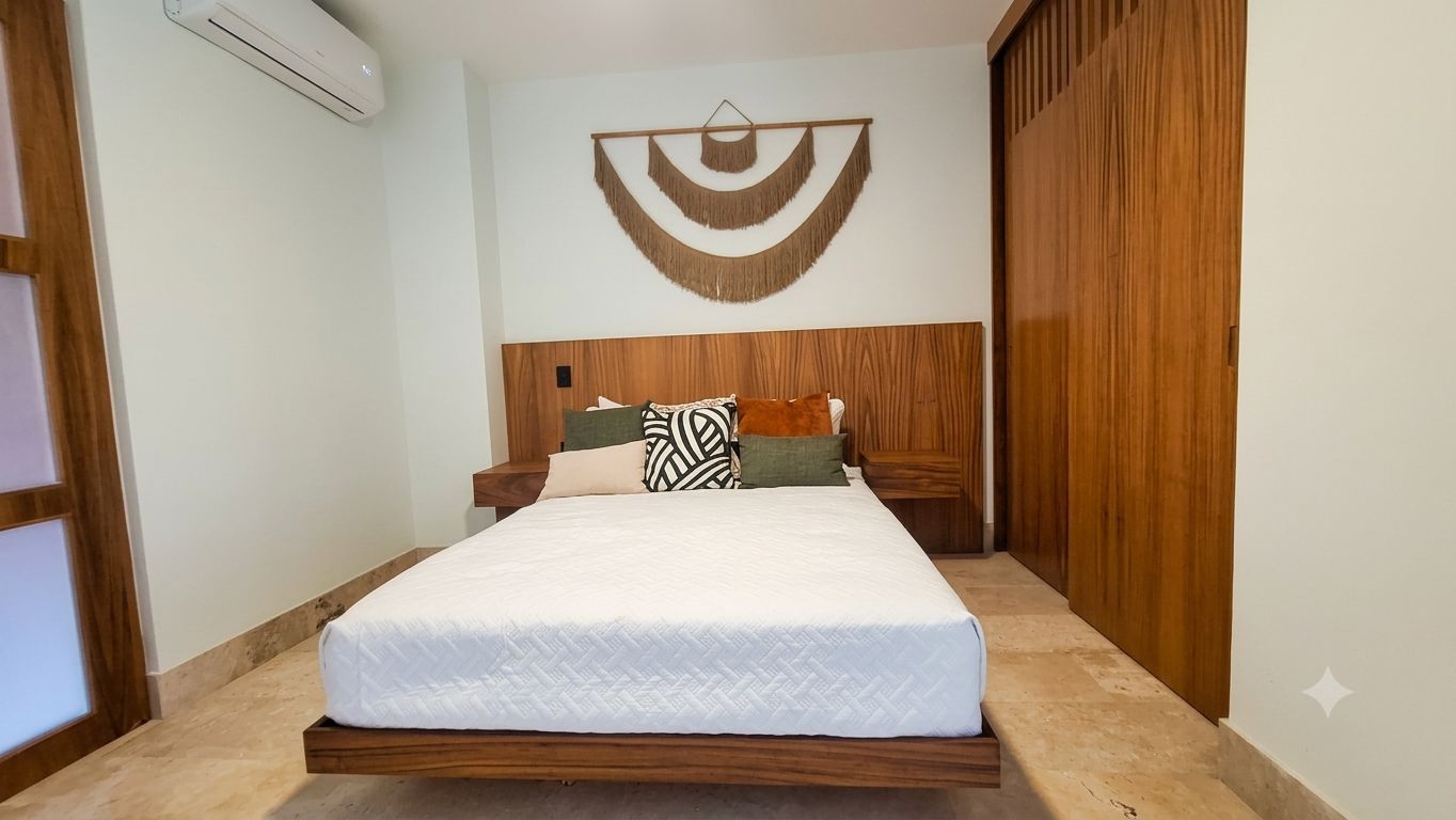 Une chambre à coucher avec un lit, une tête de lit en bois et un climatiseur fixé au mur.