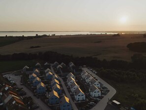 A residential area with houses arranged in a grid pattern, a road, and a body of water in the background. - 4 Star Holiday Home in Sagad (Sagard)