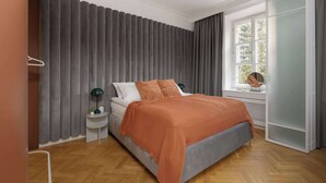 A bedroom with a bed, a nightstand, a lamp, a window with curtains, and a wardrobe. - Atmospheric Apartment in the New Town | Next to the Barbican (Warszawa)