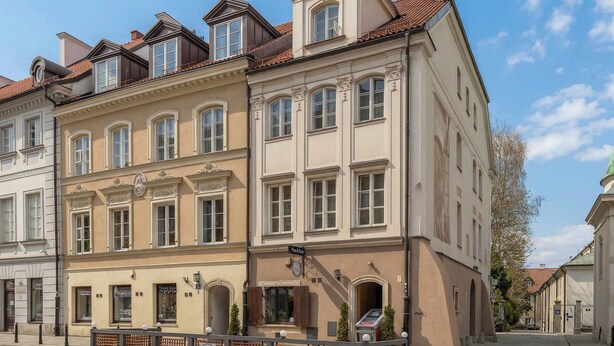 A multi-story building with a classic architectural style, featuring arched windows and a central staircase. - Atmospheric Apartment in the New Town | Next to the Barbican (Warszawa)