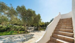 A staircase leading to a building, surrounded by greenery and a clear sky. - Casa Madili – Relax with garden, jacuzzi and holiday vibes 🌿☀️ (Porto Columbu-Perd'È Sali)