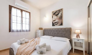 A bedroom with a bed, a bedside table, a lamp, a window with curtains, and a wall-mounted artwork. - Casa Madili – Relax with garden, jacuzzi and holiday vibes 🌿☀️ (Porto Columbu-Perd'È Sali)