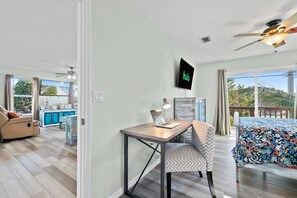 Ein modernes Wohnzimmer mit Essbereich, einem an der Wand befestigten Fernseher und einem Balkon mit Blick.