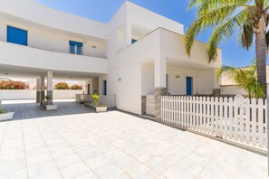 A modern building with a flat roof, white exterior walls, and blue windows. - Apartment 'Residence La Perla - Ametista' (Marina di Mancaversa)