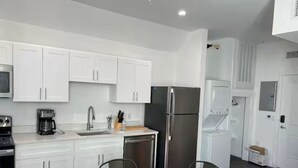 A modern kitchen with white cabinets, stainless steel appliances, and a marble countertop. - ATX Nice Studio Walking distance to the Drag! (Austin)