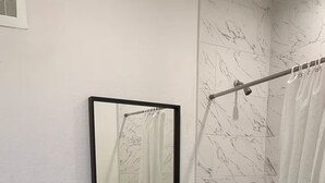 Een badkamer met toilet, wastafel, spiegel en bad.