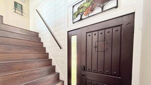 A staircase leading to a dark wooden door with a metal handle and a small window. - Wide Sky Chateau Lake Views (Osage Beach)