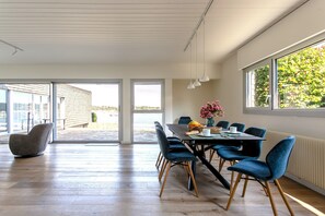 Un comedor moderno con una mesa, sillas y vistas amplias por las ventanas.