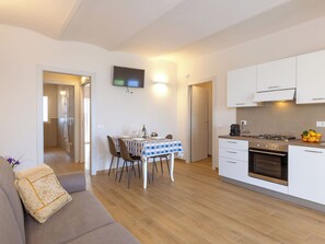 A modern apartment with a dining area, kitchen, and living room.