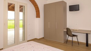 A bedroom with a bed, a desk, a chair, a wardrobe, and a TV. - Apartment I Pini by Interhome (Bibbona)