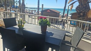 Un balcone con tavolo, sedie e piante in vaso.