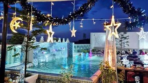 A decorated indoor pool area with a fountain, potted plants, and string lights. - Dar Lala Fatma (Algiers)