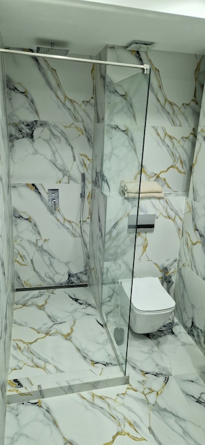 Een douche, een haardroger, een bidet, handdoeken