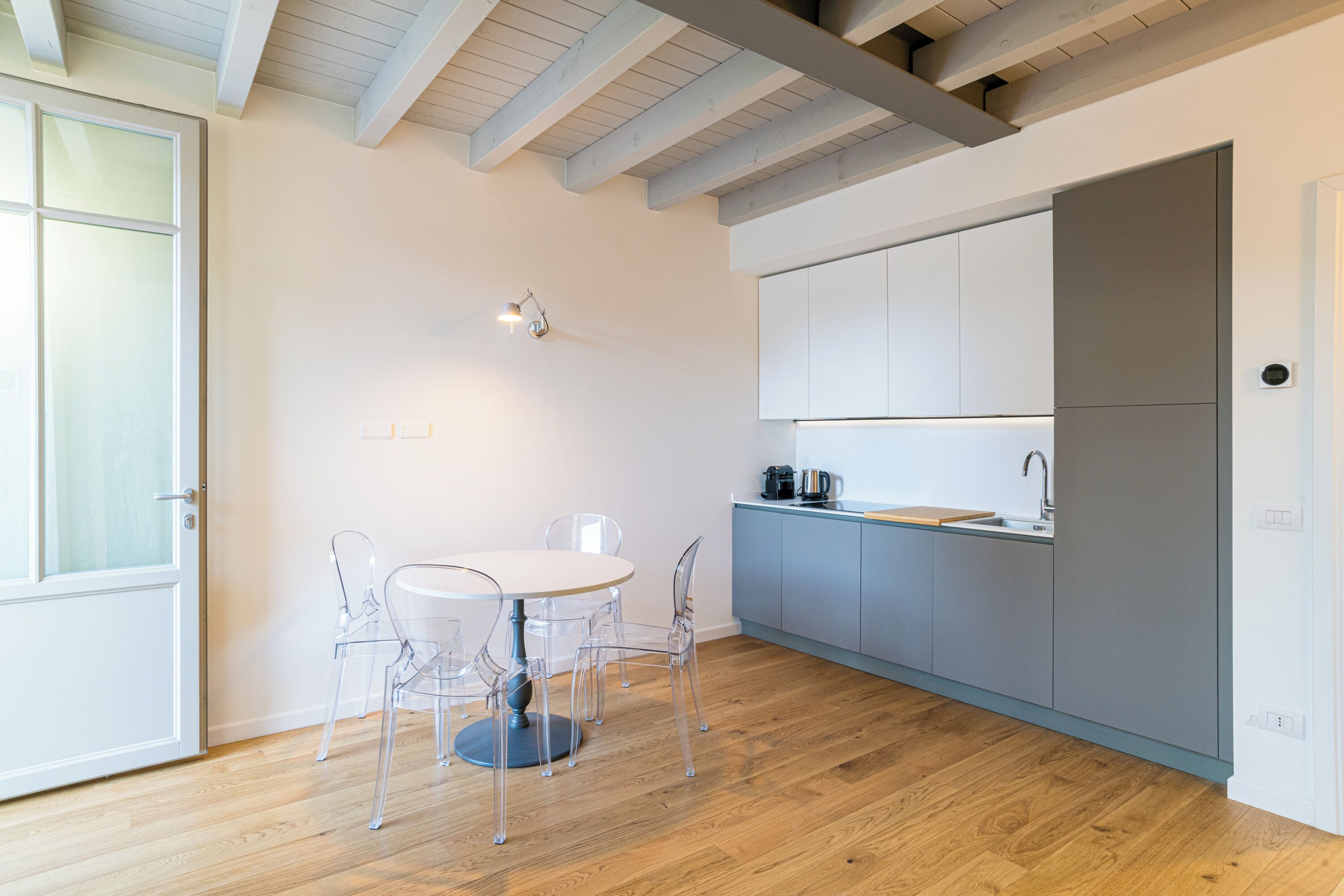 Une cuisine moderne avec une table ronde et des chaises, un four encastré et un évier.