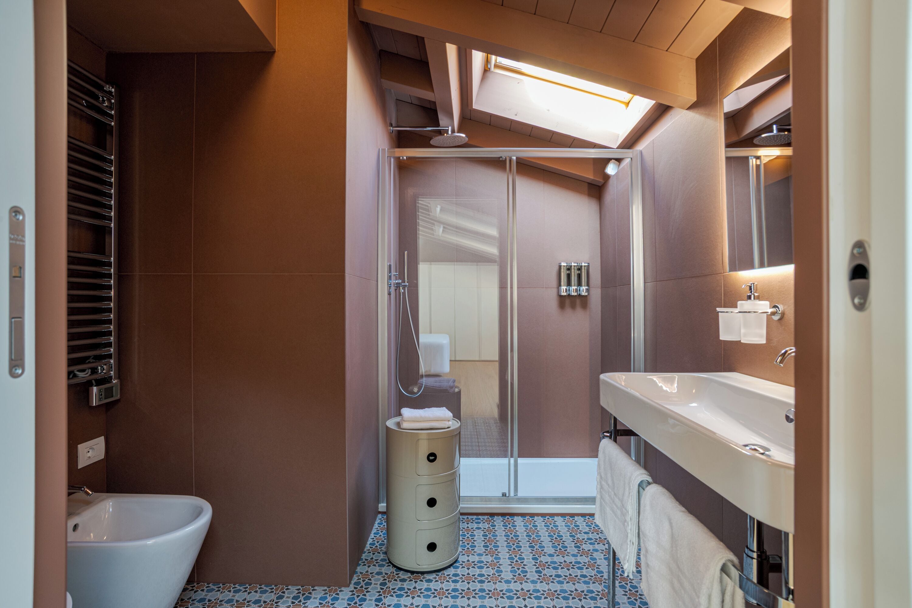 A modern bathroom with a shower, toilet, and sink.