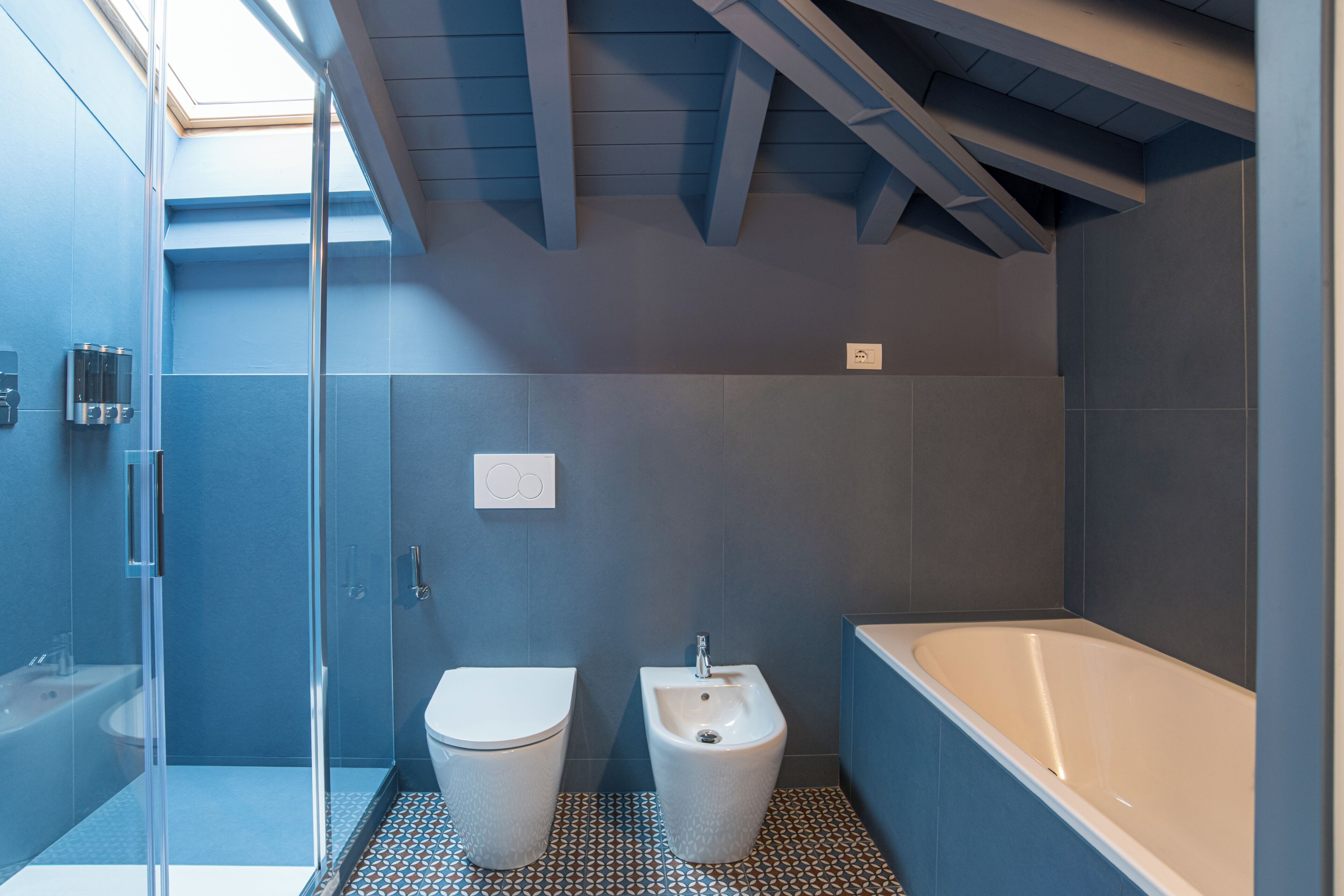 A modern bathroom with a shower, toilet, bidet, and bathtub.