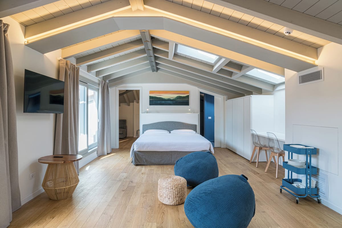 Un dormitorio con cama, televisor, escritorio y silla.