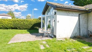 Una casa con un patio, un piccolo giardino e cielo sereno.