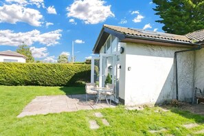 Una casa con patio, un jardín pequeño y cielo despejado.