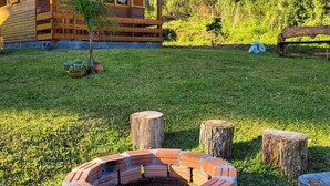 Una cabaña de madera con un hogar circular de ladrillo rodeado de troncos de árboles.