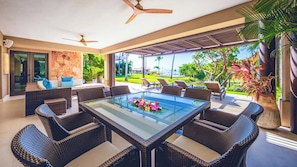 A modern outdoor dining area with wicker furniture, a glass-top table, and ceiling fans. - Ground Floor Punta Mita Condo with Shared Pool (Punta Mita)