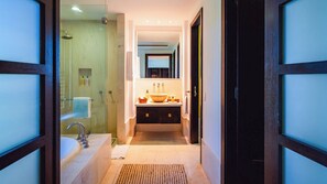 Une salle de bain moderne dotée d’une douche à parois de verre, d’une baignoire sur pieds et d’un meuble-lavabo avec un grand lavabo en forme de coupe.