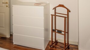 Una habitación con un aparador blanco, una estantería de madera y una puerta.
