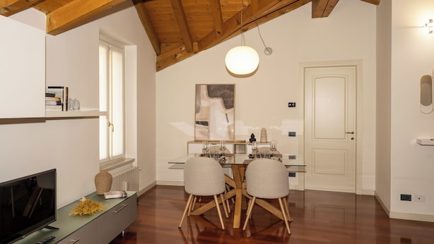 Un comedor con techo de madera, una mesa de vidrio y dos sillas.