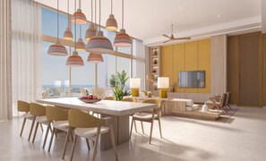 Un comedor moderno con una mesa grande, varias sillas, lámparas colgantes y vista al océano.