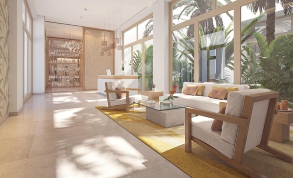 Un vestíbulo moderno con mostrador de recepción, zona de estar y amplias ventanas con vistas a la zona tropical.