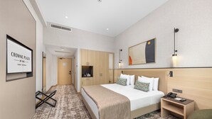 A hotel room with a bed, bedside table, wardrobe, and a framed sign on the wall. - Crowne Plaza Istanbul Zeytinburnu By Ihg (Istanbul)