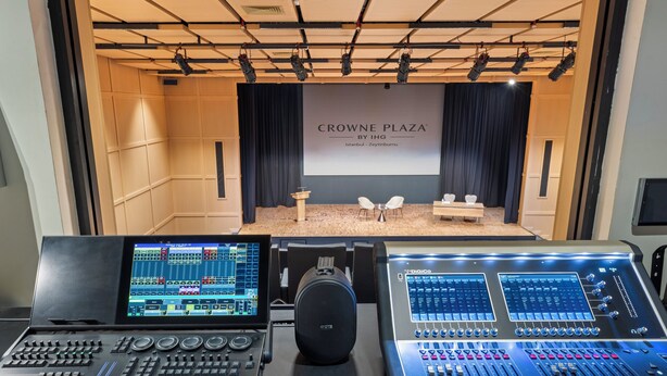 Ohjaamo, jossa on äänimiksauspöytiä, esiintymislava, jossa näkyy suurelta näytöltä teksti ”CROWNE PLAZA BY IHG Istanbul - Zeytinburnu”, sekä oleskelualue, jossa on pöytiä ja tuoleja.