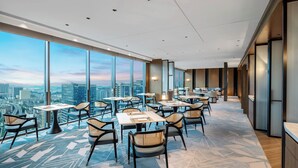 A modern hotel lobby with high ceilings, large windows, and a city view. - Hualuxe Guiyang Financial City (Guiyang)