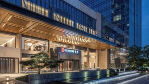 A modern hotel with a prominent entrance, a well-lit facade, and a water feature in front. - Hualuxe Guiyang Financial City (Guiyang)