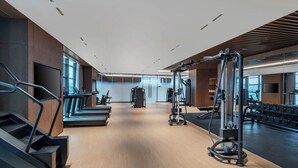 A modern gym with treadmills, weight machines, and dumbbells. - Hualuxe Guiyang Financial City (Guiyang)