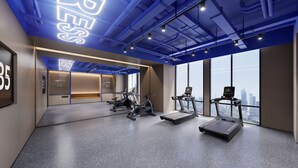 Ein modernes Fitnessstudio mit Trainingsgeräten, großen Fenstern und Blick auf die Stadt.