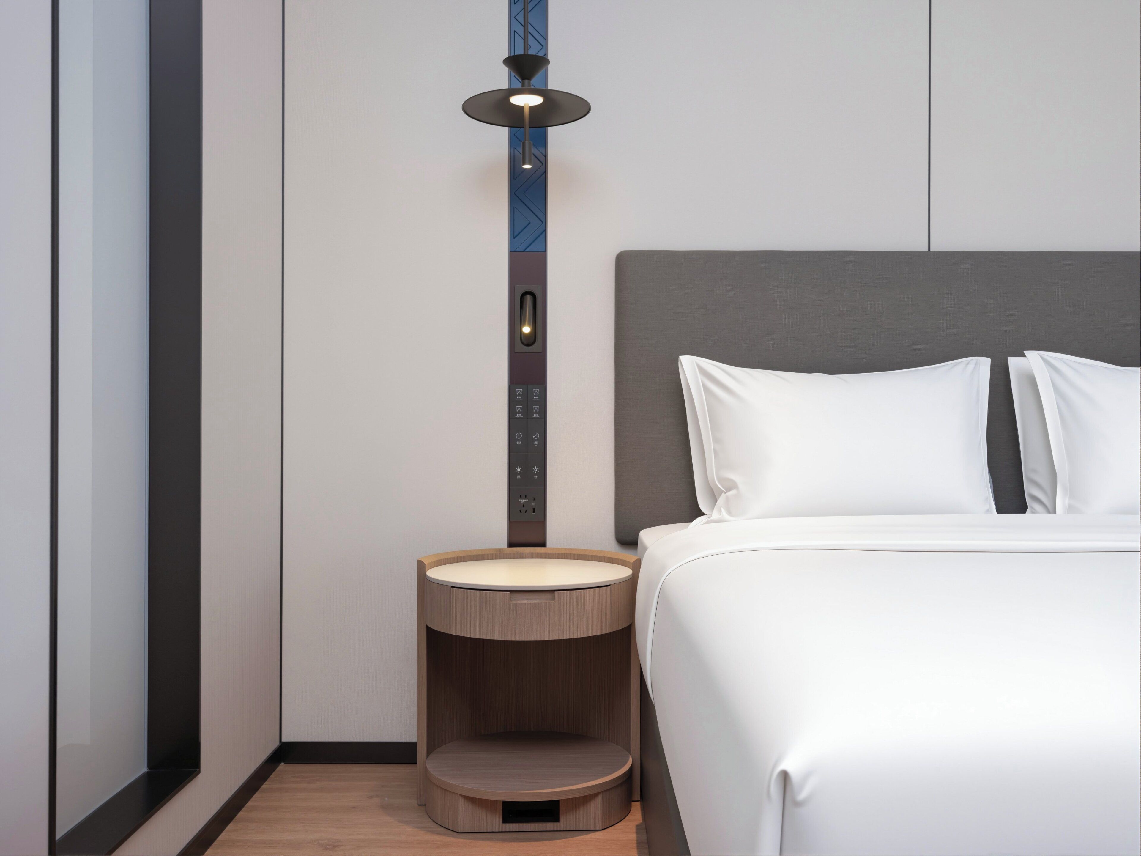 Una camera d'albergo moderna con un letto, un comodino e una lampada a parete.
