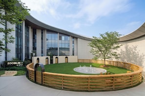 A modern building with a circular courtyard, a fountain, and a wooden fence. - Kimpton Nine Trees Shanghai By Ihg (Shanghai)