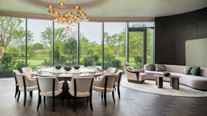 Un espace repas moderne avec une table ronde, des chaises et un lustre.