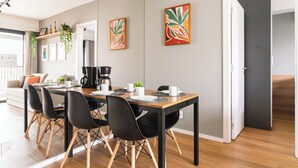 A modern dining area with a wooden table, black chairs, and a coffee machine. - Expand Pinheiros  (São Paulo)