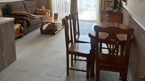 Un soggiorno con un divano, un tavolo da pranzo con sedie, un tavolino e una ventola a soffitto.